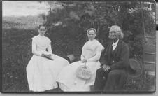 SA0066 - Two women, one of whom is not identified, and 1 man sitting outside.